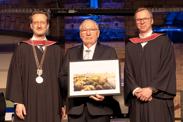 Gruppenfoto, Professor in der Mitte hält Foto in der Hand
